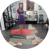 Keelie Robinson standing on a stack of Pat Conroy novels at the Pat Conroy Literary Center, Beaufort, South Carolina