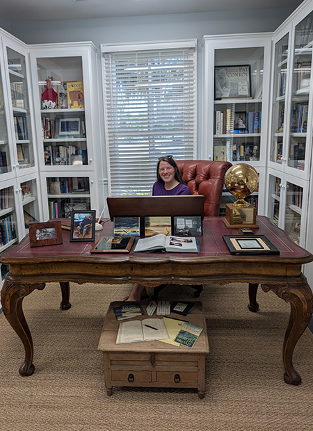 Keelie Robinson sitting at Pat Conroy's desk at the Pat Conroy Literary Center in Beaufort, South Carolina
